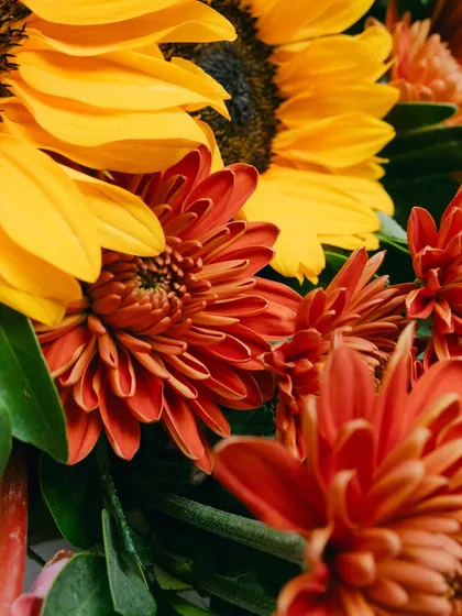 A close-up of the rich textures and colors of the sunflowers and chrysanthemums used in the floral arrangements.