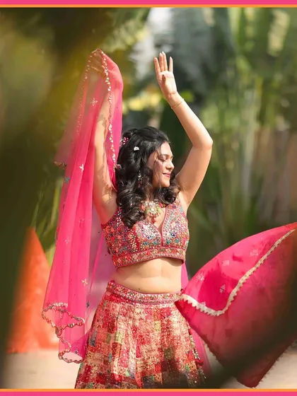 The bride, Tanushree, dancing with joy during her Mehendi. Her vibrant pink lehenga perfectly complements the festive mood.