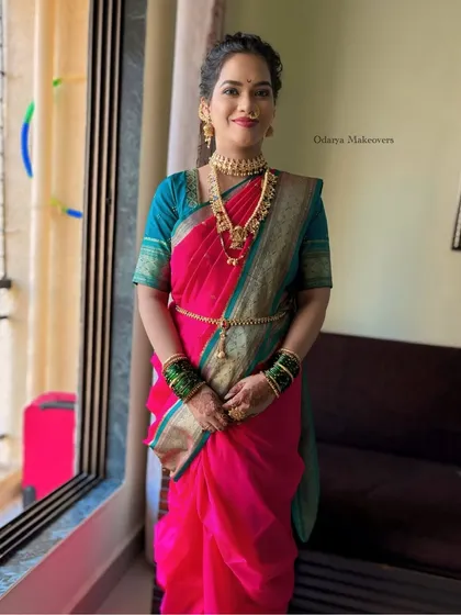 A full-length photo of a stunning Maharashtrian look. The Nauvari saree is draped perfectly, and the makeup is traditionally appropriate with a bindi and gold jewellery.