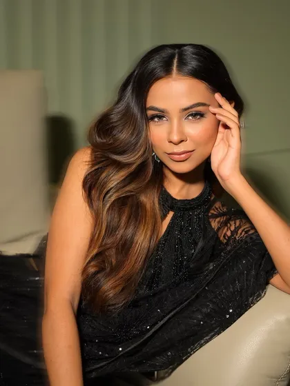 A soft and sultry pose from a cocktail lookbook. The makeup is flawless, with a focus on the eyes and a smooth, matte complexion that looks luxurious and modern.