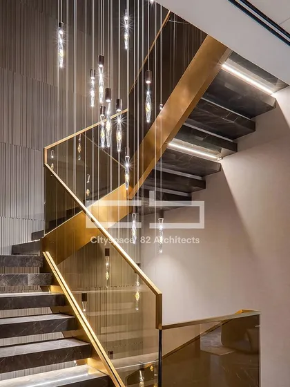 A staircase is more than a connection between floors; it is a sculptural element within the home. This design features sleek dark marble, subtle cove lighting, and elegant glass railings with gold accents, creating a journey of modern luxury.