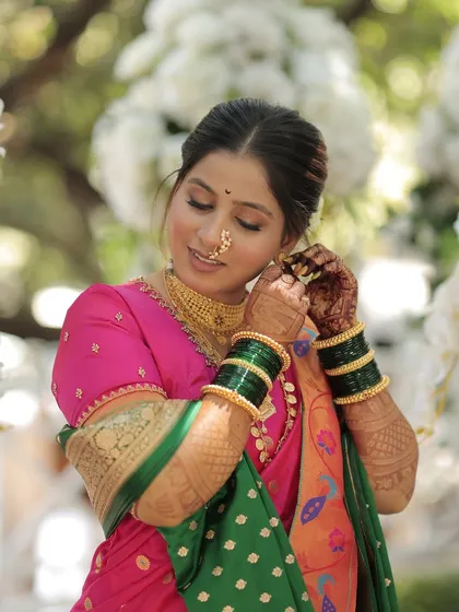 The bride adjusts her earring, giving a lovely view of her makeup and jewelry.