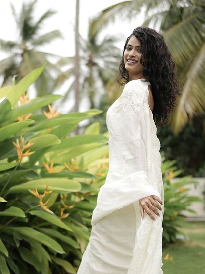 A full shot showing the flow of the white saree and the natural, breezy feel of the look.