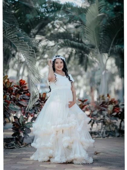 A playful and happy shot in the white ruffled gown. The floral crown adds a bohemian touch to this classic dress.