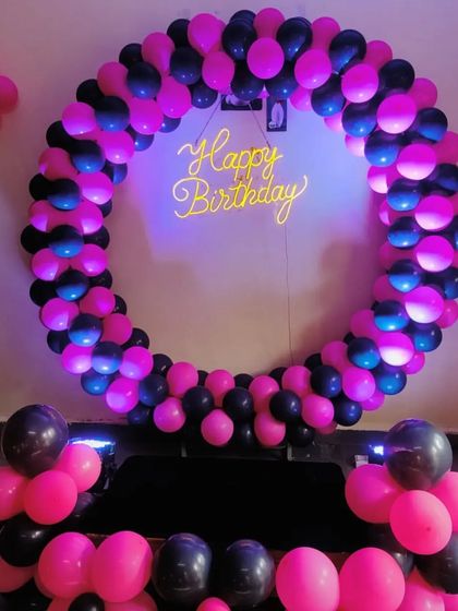 A striking birthday ring in hot pink and black, with uplighting to create a cool, modern party vibe.