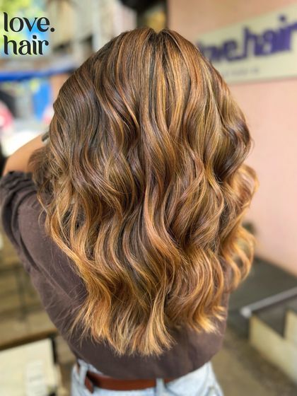 The back view of the 'molten lava' bronde, showing off the salon's logo and the fiery, dimensional colour.