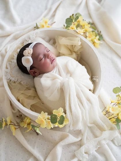 A beautifully composed portrait using a white bowl and flowing fabrics to create a soft, cloud-like bed for this sleeping baby.