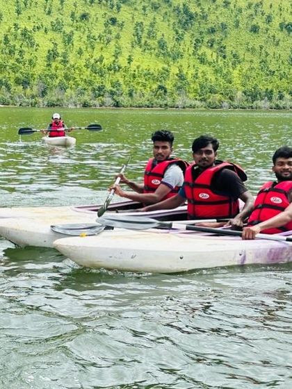 Three campers navigate their kayaks across the lake, demonstrating the skills they've acquired.