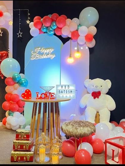 A romantic and cute setup with blue back-lit panels, a neon sign, and a large teddy bear prop.