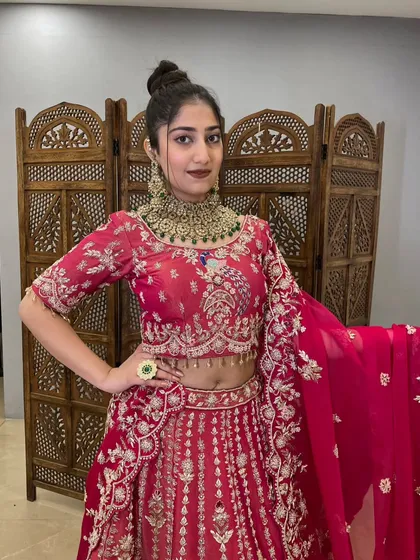 This vibrant pink lehenga with heavy gold jewelry is a stunning bridal or festive look.