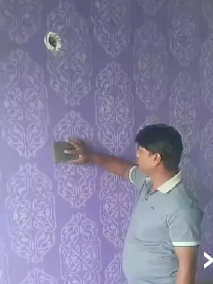 Here, one of our team members is applying a classic damask stencil pattern to a rich purple wall. This technique requires careful alignment and application to ensure a seamless, continuous design across the entire surface.