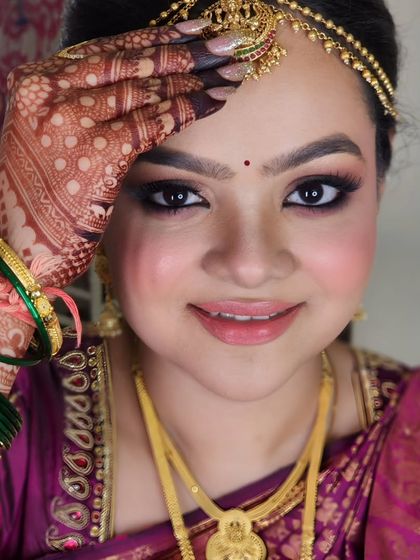 A playful and traditional pose from Shivangi. Her henna-covered hand beautifully frames her face, showing off the detailed eye makeup and traditional bindi.
