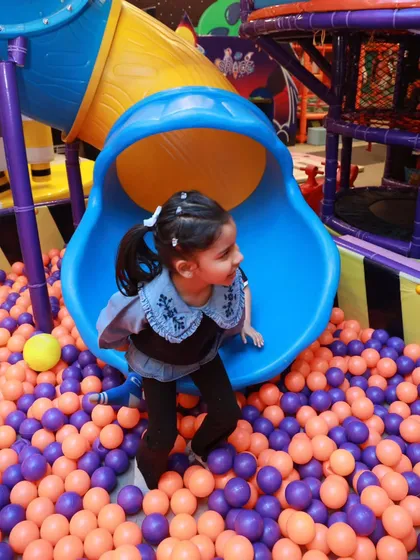 A happy moment at the bottom of the slide. Our ball pit is filled with thousands of soft, colorful balls, making for a safe and fun landing every time.