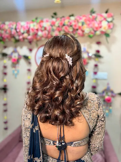 The hairstyle for the Sangeet was voluminous Bollywood waves, half-tied and adorned with delicate crystal accessories for extra sparkle.