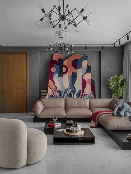 This living space in Upper Juhu, Mumbai, is a study in contrasts, designed for a young, sophisticated couple. We balanced the industrial feel of raw concrete with a bold, colourful accent wall and curated abstract art, creating an environment that is both refined and full of personality. The design seamlessly integrates areas for relaxation and social engagement.