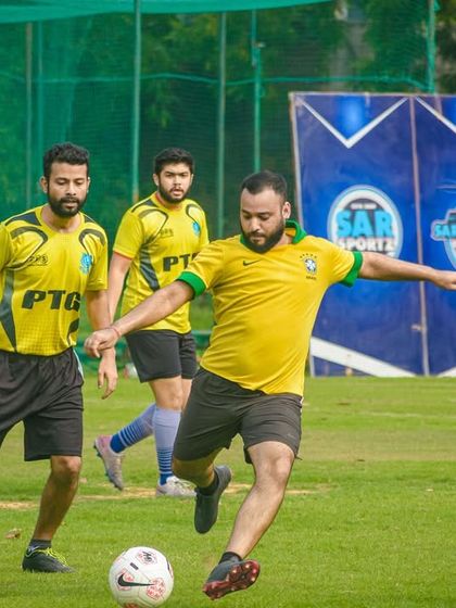 A player in a yellow jersey prepares to unleash a powerful shot during a Pride Cup match.