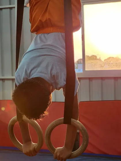 Using apparatus like the Roman rings helps build incredible upper body and core strength. We guide students of all ages in using our professional-grade equipment to develop their skills safely.