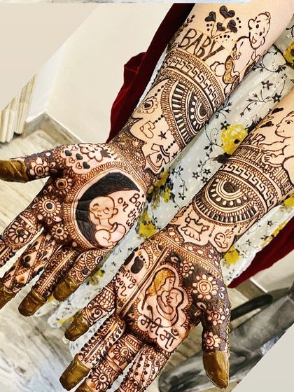A beautiful and detailed baby shower mehndi for a mom-to-be. The design includes a baby sleeping on the moon, a mother holding her child, and other sweet, symbolic motifs.