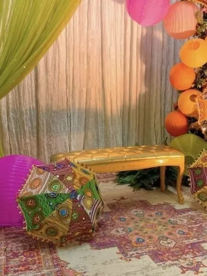 A cozy corner for a home Mehndi function. I use elements like colorful umbrellas, paper lanterns, and traditional rugs to create fun and photogenic spaces for your guests.