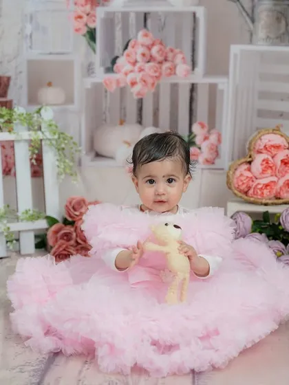 Holding her little teddy bear, this baby girl is the star of her floral-themed sitter session.