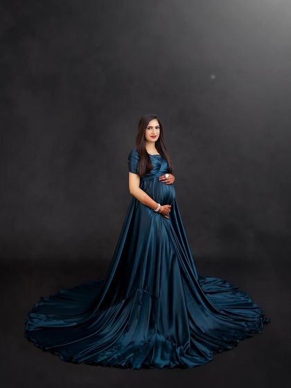 A stunning portrait in a deep teal satin gown. The fabric drapes beautifully, creating a look of pure elegance and luxury.