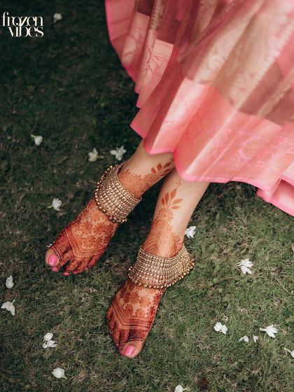 A detailed shot of the bride's feet, adorned with stunning anklets and intricate mehndi. I believe in capturing every detail that completes the bridal story.