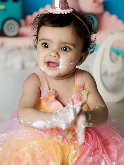 The moment of pure joy and a little bit of mischief. Getting messy with cake is the best part of a first birthday shoot.