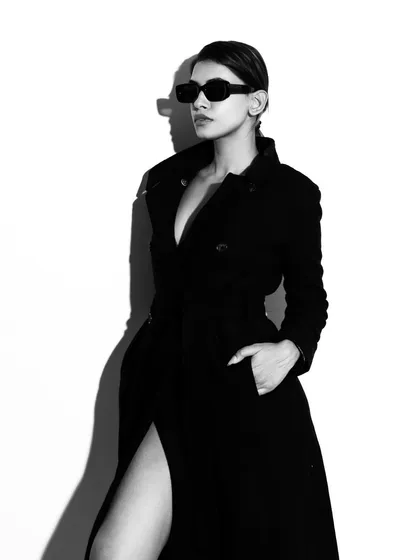 This is an example of my high-contrast studio work, creating a bold and classic fashion statement. The play of hard light and shadow defines the model's silhouette and the texture of the coat, resulting in a powerful black and white portrait.