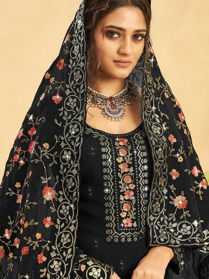 This black salwar kameez is a timeless beauty. The colorful thread embroidery and sequins on the neckline and dupatta add a pop of festive cheer to the classic black.