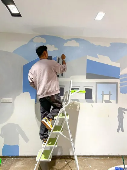 Here I am on a step ladder, blocking in the first layers of color for a new mural. Every piece starts with a blank wall and a vision, and this is the moment it starts to take shape.