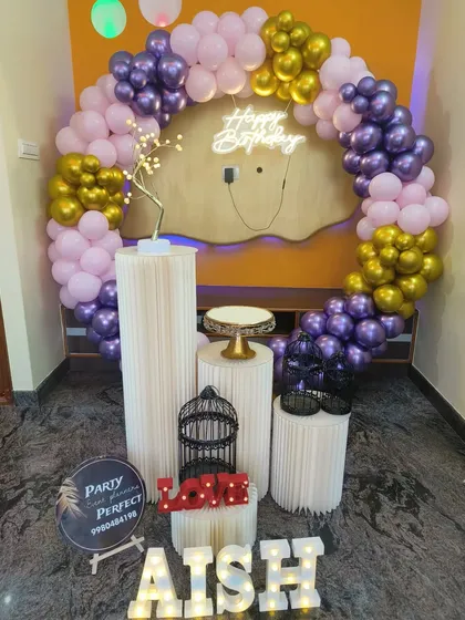 This home decoration for Aish's birthday uses a beautiful palette of pink, purple, and gold. The balloon ring, neon sign, and light-up name create a festive focal point in the room.