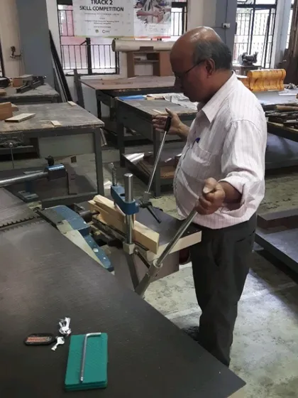 An instructor demonstrates the proper stance and operation of the mortising machine.