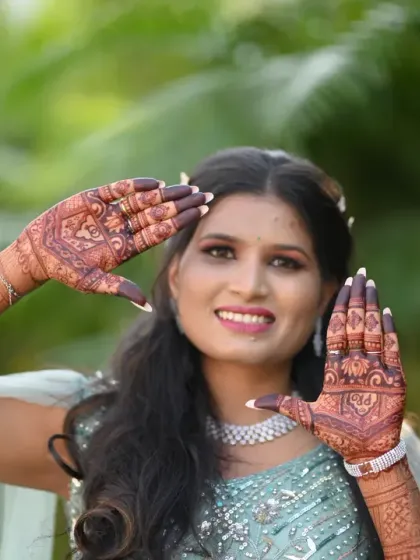 A happy bride-to-be playfully showing off her engagement mehendi. Her joy is infectious and shows how mehendi is a fun part of the wedding celebrations.