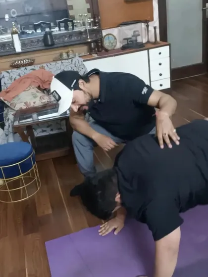 I bring the training to your doorstep. Here, I'm correcting a client's form during a bodyweight exercise in the comfort of their home in Indirapuram.