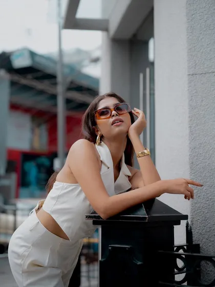 Creating compelling angles is key to my fashion photography. This low-angle shot makes the all-white outfit feel powerful and aspirational, using the urban architecture as a clean, modern backdrop for a contemporary fashion label.
