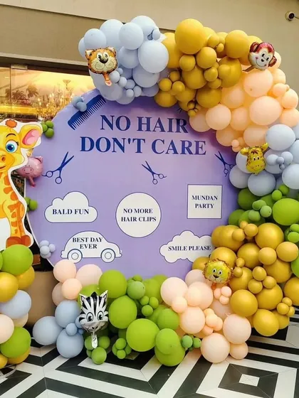 A fun and playful "No Hair Don't Care" theme for a Mundan ceremony. This setup features a custom backdrop, a vibrant pastel balloon arch, and adorable jungle animal cutouts like a giraffe and zebra.