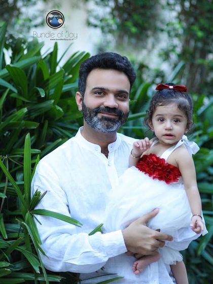 A beautiful father-daughter portrait from an outdoor family session, showcasing their connection against a natural, green backdrop.