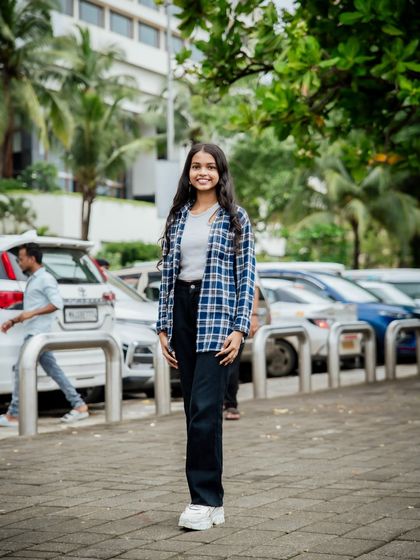 A final shot from the series, showing a confident stance against an urban backdrop of parked cars and buildings.