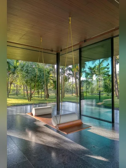 We design moments of pure tranquility. This simple swing, suspended in a glass-walled pavilion, offers an immersive experience of the surrounding coconut grove, providing a quiet corner to pause, reflect, and connect with nature.