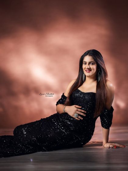 A beautiful smile from this mom-to-be, looking radiant in a sparkling black off-the-shoulder gown.