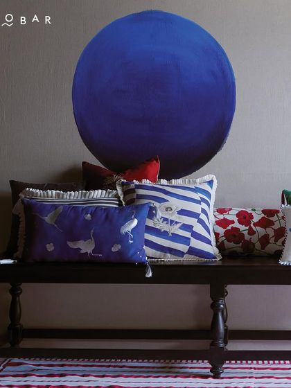 A selection of Nicobar's home decor, featuring beautifully designed cushions with intricate patterns and rich colors. Their style extends from your wardrobe to your living space.