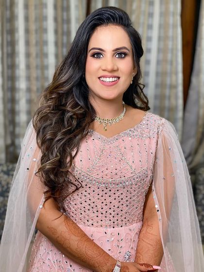 A full-length shot of Aashi, looking elegant and happy in her pink gown with a sheer cape.