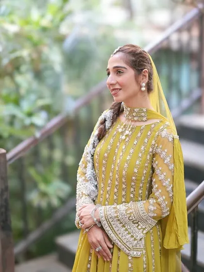 A thoughtful portrait of the bride on a wooden staircase. The natural setting and her elegant pose create a serene and beautiful image during her wedding festivities.