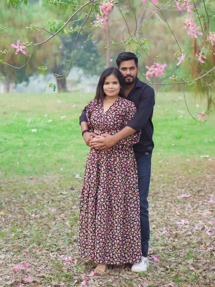 A full-length portrait of the couple during their pre-wedding shoot, showcasing their coordinated style and the beautiful outdoor scenery.