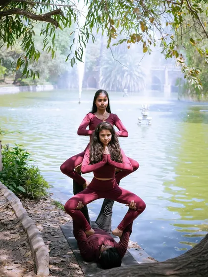 A perfectly aligned three-person acroyoga pose, showcasing the focus and stability of the entire team.