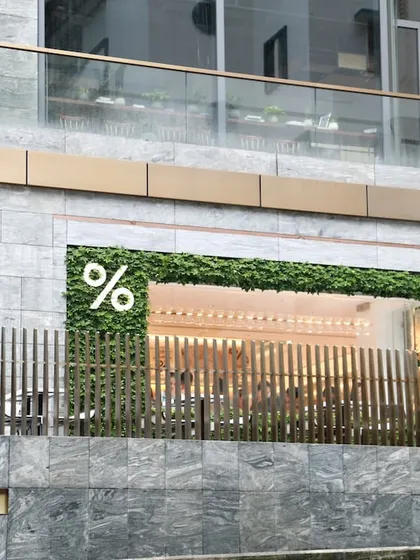 Greenery can elevate a commercial brand. For this storefront, I installed a clean, modern artificial green wall that frames the entrance, making it more inviting and memorable for customers.