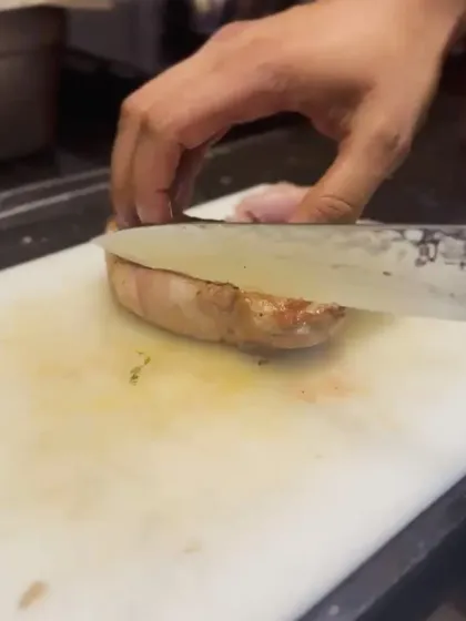 Slicing into a perfectly cooked duck breast. This shot reveals the juicy, pink interior, a hallmark of proper technique.