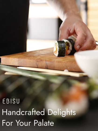 Handcrafted delights for your palate. Our chef carefully slices a freshly made sushi roll, ensuring each piece is perfect. This is the dedication that defines our kitchen.