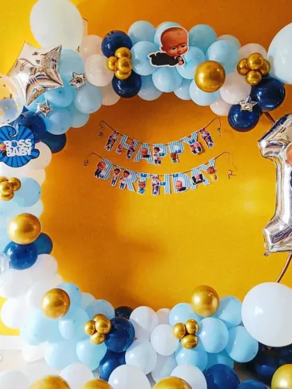 A simple Boss Baby first birthday balloon ring. This decoration is perfect for smaller spaces or home parties, featuring blue, white, and gold balloons with Boss Baby accents.