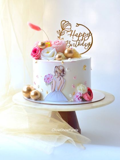 A closer look at the "cake for her," highlighting the floral details and the elegant topper.